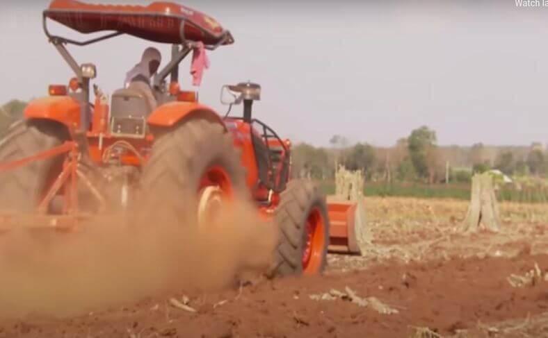 Tractor preparing the land for cassava commercial farming