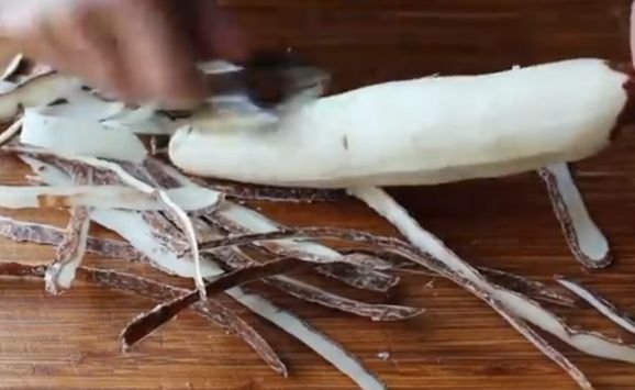 Peeling yuca roots for baked yuca fries