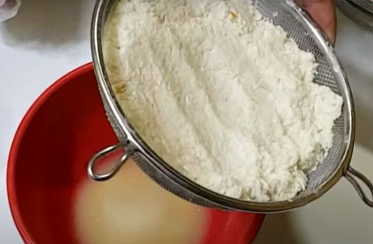 Draining the grated cassava to remove moisture