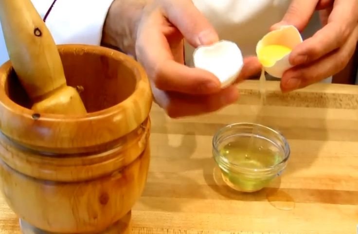 Adding egg yolk to the garlic and salt paste