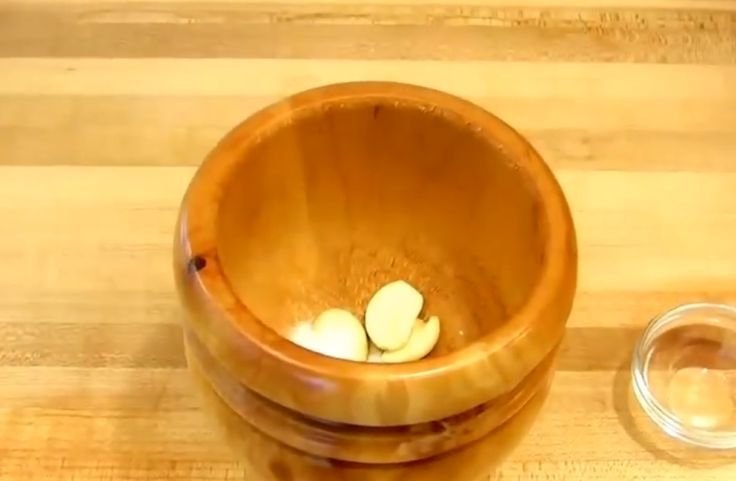 Garlic and salt in a mortar about to be crushed