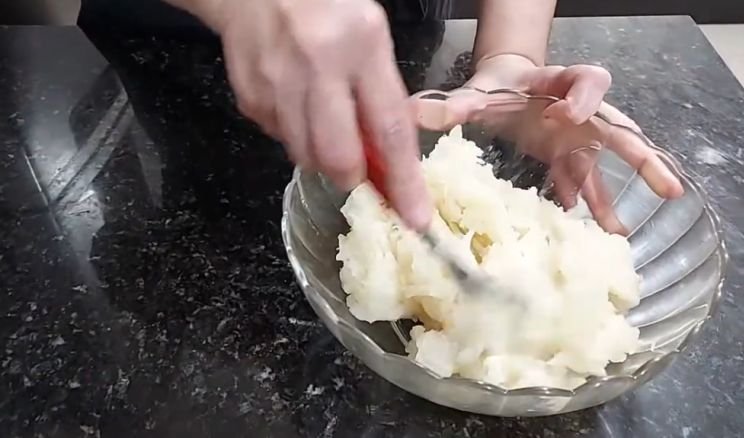 Mashing the boiled cassava root